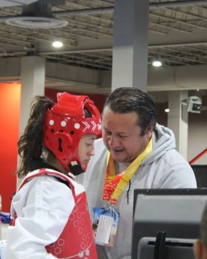 Master Castillo instruyendo a una atleta durante una competencia